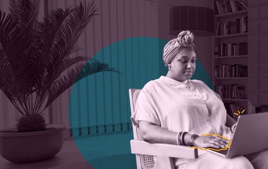 Femme africaine utilisant un ordinateur portable assise dans un fauteuil.