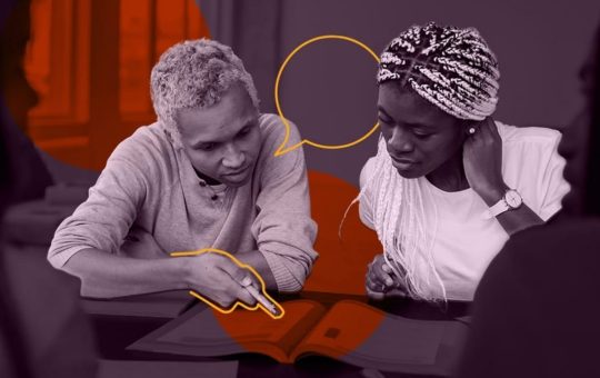 Un homme et une femme autours d'une table qui parlent, il montre quelque chose sur une page disposée entre eux, ils en partage la lecture